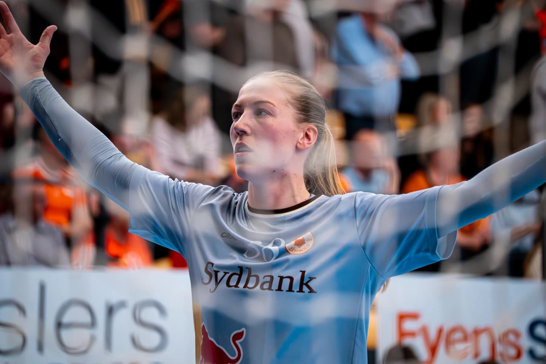 Team Esbjerg-målmand med klublogo og Sydbank på trøjen i defensiv stilling set gennem målnet i arena — fotograf i Ribe